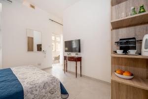 a bedroom with a bed and a bowl of fruit on a table at Vela Blu Boutique Suites in Il-Gżira