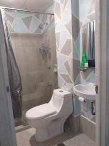 a bathroom with a toilet and a sink at Cozy Condominium near Mactan International Airport in Mandaue City