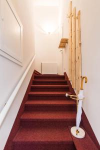 una scala con un tappeto rosso e un ombrello sopra di Apartment Alexandra a Gmunden