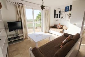 a living room with a couch and a tv at El Gouna spacious flat in Steigenberger Golf in Hurghada