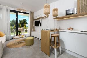 a kitchen and living room with white cabinets and a table at NiSea Beach Apartments in Prinos