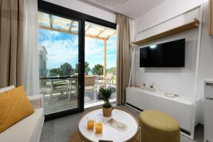 a living room with a table and a large window at NiSea Beach Apartments in Prinos
