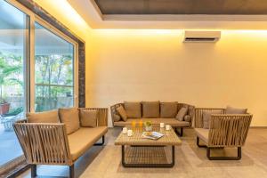 a living room with a couch and chairs and a table at StayVista's Verde Villa with Private Pool, Games Room & Terrace in Lonavala