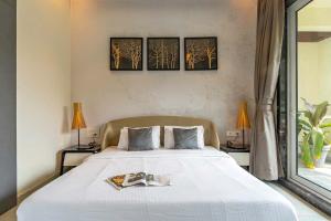 a bedroom with a large white bed with three paintings on the wall at StayVista's Verde Villa with Private Pool, Games Room & Terrace in Lonavala +26 photos