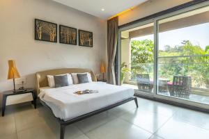 a bedroom with a large bed and a large window at StayVista's Verde Villa with Private Pool, Games Room & Terrace in Lonavala