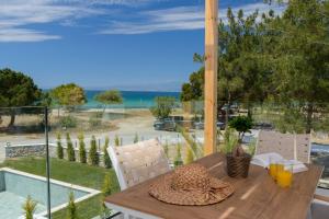 a table and chairs with a view of the ocean at NiSea Beach Apartments in Prinos