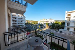 balcone con tavolo, sedie e vista sulla strada di CLASS Hotel a Ksamil