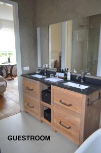 uma casa de banho com um lavatório e um espelho grande em Huis aan Honte em Dishoek