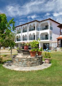 a large white building with potted plants in front of it at Studios Halkia in Toroni