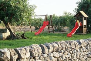 un parque infantil con 2 toboganes y un columpio en Masseria Cianciò en Casa Serrafiori