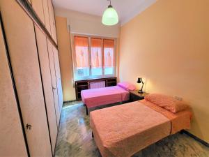 Zimmer mit 2 Betten und einem Fenster in der Unterkunft Appartamento Pilloa in La Spezia