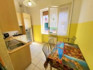 eine Küche mit einem Tisch, einem Tisch und Stühlen in der Unterkunft Appartamento Pilloa in La Spezia