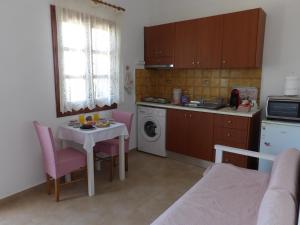 kuchnia ze stołem oraz niewielka kuchnia ze stołem i krzesłami w obiekcie TEO 1 Apartment w mieście Guwes