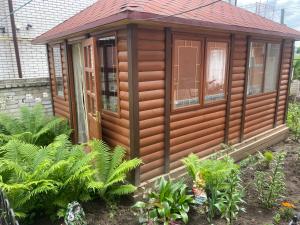Cabaña de madera en un jardín con plantas en Eleon, en Uman