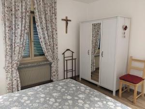 um quarto com uma cama e uma cruz na parede em Casa Vanna em Mezzano