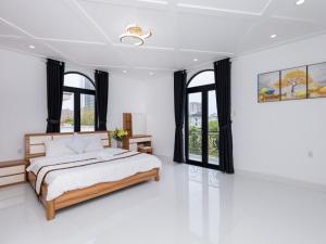 - une chambre blanche avec un grand lit et des fenêtres dans l'établissement Pallas Villa, à Vung Tau 40 autres photos