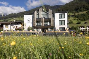 ein großes weißes Gebäude mit einem Blumenfeld in der Unterkunft Max Mountain Apartments in Neustift im Stubaital