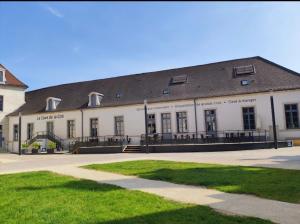 duży biały budynek z czarnym dachem w obiekcie Charmant appartement Cité international - Gastronomie & Vin - Dijon w mieście Dijon