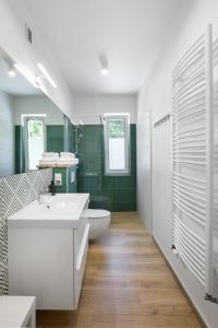 a bathroom with a white sink and a toilet at Apartamenty Wczasowa - komfort z narciarnią in Kudowa-Zdrój