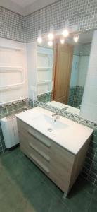 a bathroom with a sink and a large mirror at APARTAMENTO PLAYA FOZ CON TERRAZA in Foz
