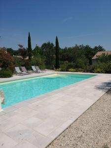 - une piscine d'eau bleue et des chaises longues dans l'établissement Chambres d'hôtes Le Mas de Molines, à Vogüé