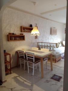 - une salle à manger avec une table, des chaises et un lit dans l'établissement bel appart dans une résidence avec piscine, à 750m de la plage. Confort garanti., à Saïdia