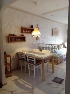a dining room with a table and chairs and a bed at bel appart dans une résidence avec piscine, à 750m de la plage. Confort garanti. in Saidia 