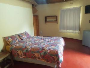 a bedroom with a bed with a colorful comforter at Lituba Lodge 