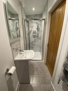 a bathroom with a sink and a shower at White Cottage - Cosy Holiday Cottage in Drymen, Loch Lomond & Trossachs in Drymen