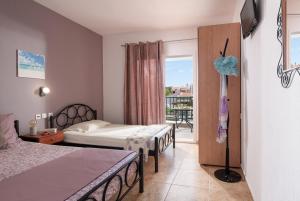 a hotel room with two beds and a balcony at Studios Halkia in Toroni