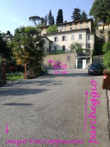 una calle con un edificio de fondo con escritura rosa en B&B Cappuccini, en Schio