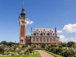 a building with a clock tower and a building with a garden at Agréable maison de 100m2 avec son parking privatif in Calais
