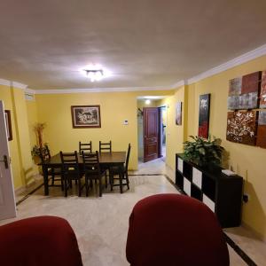 een eetkamer met gele muren en een tafel en stoelen bij 3 bedroom apartment with pool & parking, close to sea and golf in Manilva