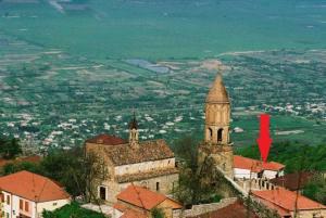 a church on a hill with a red arrow pointing at it at Guesthouse Kiko in Sighnaghi