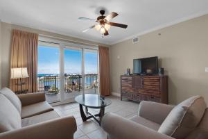 a living room with couches and a television and a table at Ariel Dunes II 704 in Destin