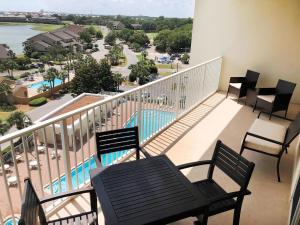 a balcony with chairs and a view of a pool at Ariel Dunes II 704 in Destin