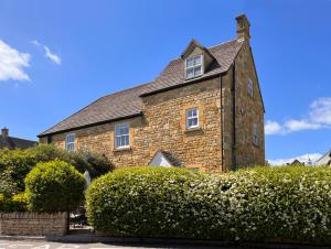a large brick building with a chimney on top at Campden Place - 2 Bed Home in Central Chipping Campden in Chipping Campden