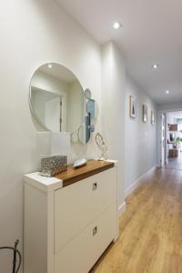 Baño blanco con lavabo y espejo en Apartamento centrico parking aire acondicionado y wifi, en Granada