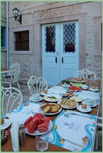 einen Tisch mit Teller mit Lebensmitteln darüber in der Unterkunft Olea Leya in Ayvalık