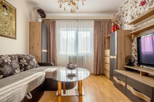 a living room with a couch and a glass table at Tourist Apartment in Klaipėda