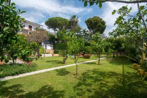 a garden with trees and a building in the background at Magnificent Villa Sanremo in Sanremo