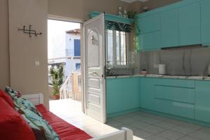una cucina con armadi blu e una finestra di Asteri Apartments Mytikas 2-Bedroom Seaview Courtyard a Mýtikas