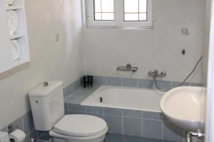 a bathroom with a toilet and a tub and a sink at Asteri Apartments Mytikas 2-Bedroom Seaview Courtyard in Mitika
