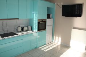 a kitchen with blue cabinets and a white refrigerator at Asteri Apartments Mytikas 2-Bedroom Seaview Courtyard in Mitika