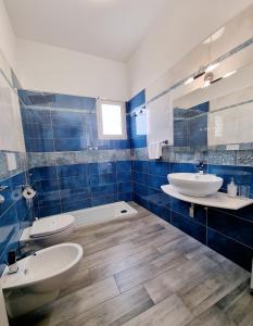 a bathroom with two sinks and two toilets at Albatros B&B Porto Cesareo in Porto Cesareo