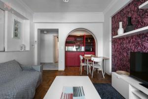 a living room with a couch and a red door at Rustique, Nilie Hospitality MGMT in Thessaloniki