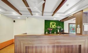 a lobby with a reception counter and green walls at IKIGAI Green Valley Beach Resort in Dona Paula