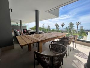 a dining room with a wooden table and chairs at Mesas Homes luxury 4 bed apartment near the sea and port Estepona in Estepona