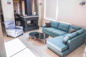 salon z niebieskimi kanapami i kominkiem w obiekcie Villa Sweven, Luxury Living Chania w mieście Suda