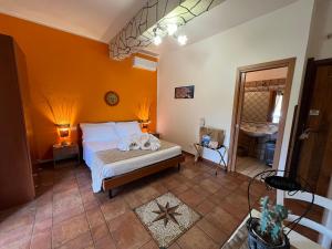 1 dormitorio con 1 cama en una habitación con paredes de color naranja en Tropea Casa Scirocco, en Tropea